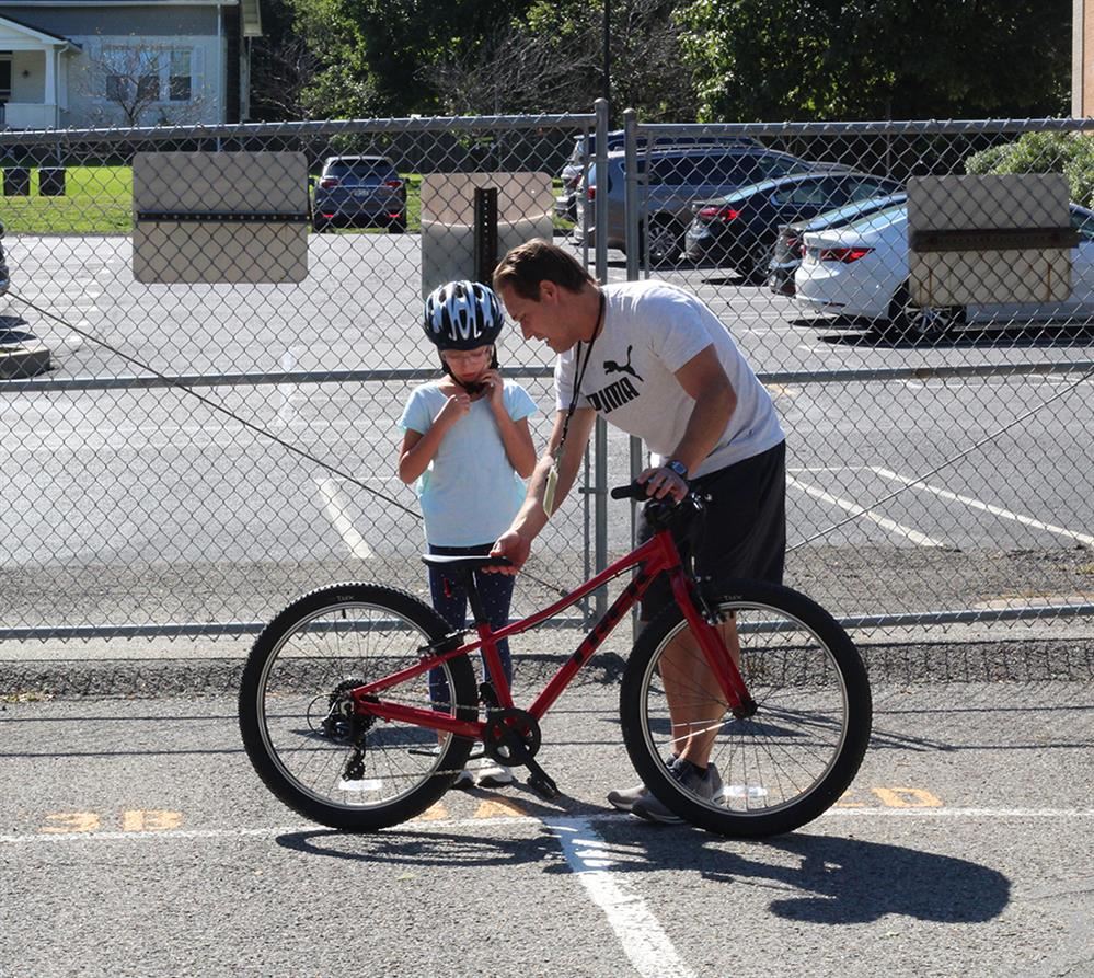 Ingomar Elementary School HPE teacher Dean Boronyak introduces biking to elementary student Amy O.